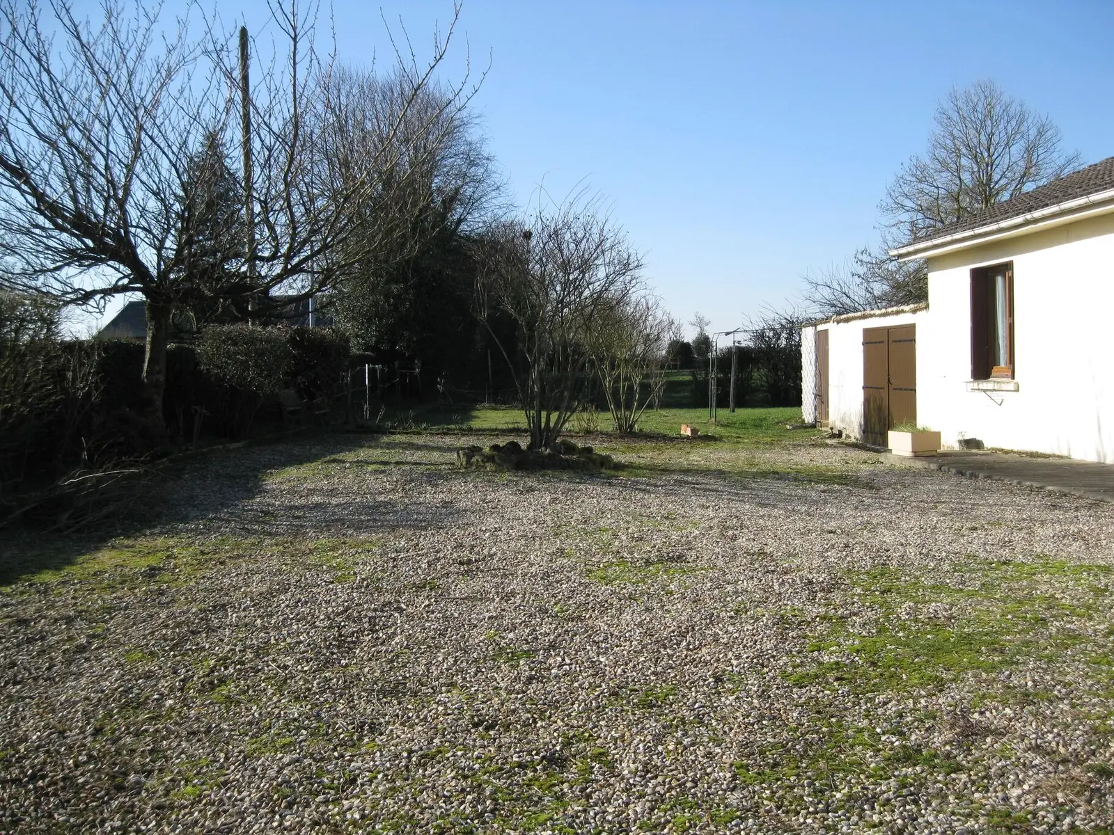 Le terrain et la cour de la maison de Beaussault, avec une haie et un abri de jardin