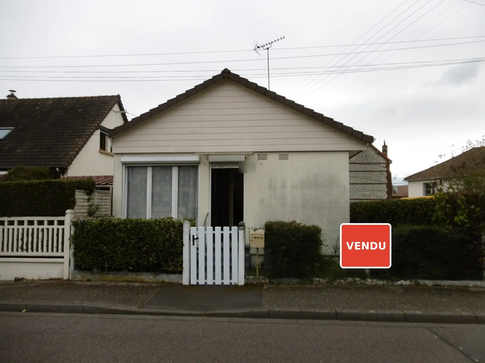 Maison de ville à Sotteville-lès-Rouen derrière sa haie, avec un panneau « Vendu »